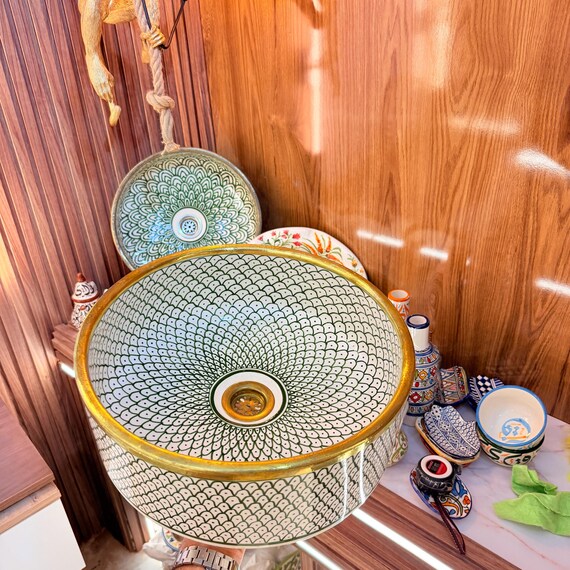 Green round ceramic sink with Hand-Fitted Brass Rim, fish scales design.