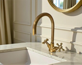 Antique copper bathroom faucet showing elegant brass details and curved spout