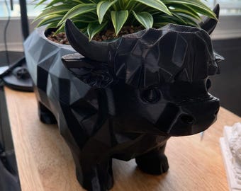 Figura geométrica de vaca, estatua negra de baja poli impresa en 3D