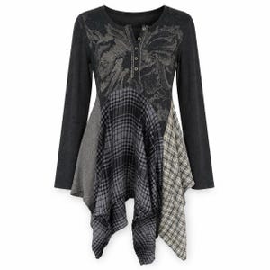 Peut inclure: Une tunique à manches longues avec un corsage gris anthracite orné d'un motif floral discret et une encolure henley à quatre boutons. La partie inférieure se compose de panneaux asymétriques aux motifs à carreaux gris et noirs.