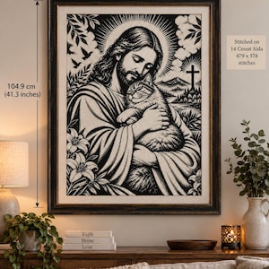 Pode incluir: Um padrão de ponto cruz em preto e branco retratando uma figura segurando um gato, emoldurado em madeira escura. A obra mede 86,9 cm por 104,9 cm, bordada em Aida de 14 pontos com 479 por 578 pontos. A cena inclui lírios e uma cruz.