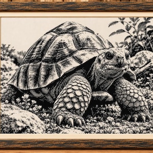 May include: A framed black and white cross-stitch embroidery depicting a detailed tortoise in a natural habitat with rocks and foliage. The artwork is encased in a dark brown textured wooden frame with a cream-colored mat border.
