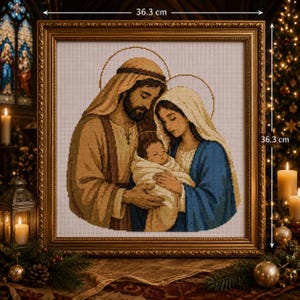 Peut inclure: Une broderie au point de croix encadrée représentant la Sainte Famille, avec Joseph, Marie et l'enfant Jésus portant des auréoles. Le cadre carré mesure 36,3 cm sur 36,3 cm. Les personnages sont brodés en fils beige, bleu et blanc.