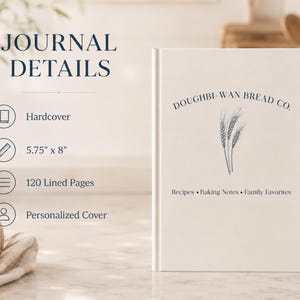 Puede incluir: Un diario de tapa dura blanco que mide 14,6 cm por 20,3 cm con 120 p&aacute;ginas rayadas y una cubierta personalizada. La cubierta presenta el texto DOUGHBI-WAN BREAD CO., una ilustraci&oacute;n de espiga de trigo y el texto Recipes, Baking Notes, Family Favorites.