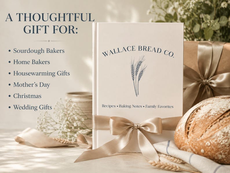 Puede incluir: Un libro de tapa dura blanco titulado Wallace Bread Co. con una ilustraci&oacute;n de espigas de trigo y el texto Recipes, Baking Notes, Family Favorites. El libro est&aacute; envuelto con un lazo de sat&eacute;n beige, junto a un pan y regalos.