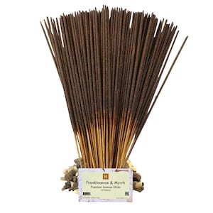 May include: A large bundle of dark brown incense sticks with light wooden bases, arranged in a fan shape. A rectangular label at the base reads Frankincense & Myrrh Premium Incense Sticks All Natural, featuring a small logo and barcode.
