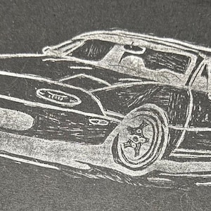 Peut inclure: Illustration en noir et blanc d'une voiture de sport. La voiture a un profil bas, avec des phares visibles, un pare-brise et des roues détaillées. L'image est une impression de style linogravure.