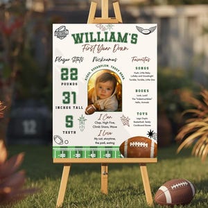 May include: A personalized football-themed sign on an easel, celebrating a baby's first year. The sign displays the name "WILLIAM'S" and includes stats: 22 pounds, 31 inches tall, and 5 teeth. It also lists nicknames, favorites, and a photo.