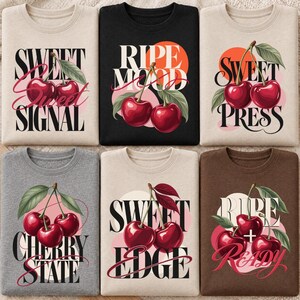 Peut inclure: Six sweat-shirts à col rond en beige, noir, gris et marron, chacun arborant un motif de cerises rouges avec des feuilles vertes et du texte noir stylisé incluant des phrases comme Sweet Signal, Ripe Mood, Sweet Press, Cherry State, Sweet Edge et Ripe + Ready.