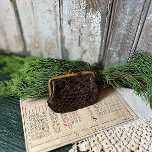 Monedero vintage de piel de cocodrilo marrón muy desgastado