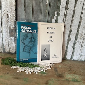May include: Two books titled "Indian Artifacts" and "Indian Flints of Ohio" are displayed. The "Indian Artifacts" book is teal with a portrait. The "Indian Flints of Ohio" book is white with a flint illustration.