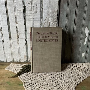 May include: A rustic wooden sign with the text "Welcome" in a handwritten style. The sign is painted white with a distressed finish, and features a decorative floral element in the corner. The background is a blurred image of a wooden surface.