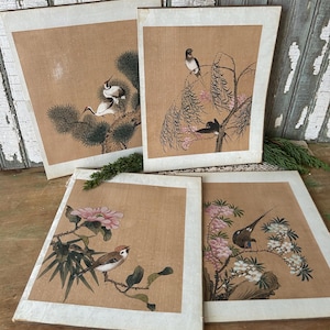 May include: Four framed vintage prints featuring birds and floral elements. The artwork showcases detailed illustrations of birds perched on branches with flowers and foliage, set against a tan background with white borders. The prints have a classic, antique aesthetic.