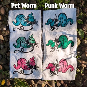 May include: White fabric squares with colorful worm illustrations. The worms are in shades of blue, green, and pink, with spiky collars and the text "Pet Worm" and "Punk Worm".