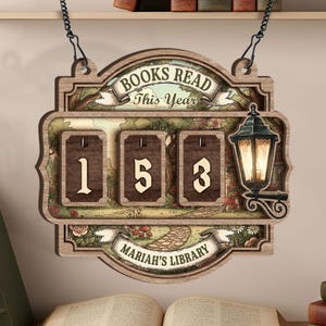 May include: Wooden sign with the text "BOOKS READ This Year" and "MARIAH'S LIBRARY". The sign has three number displays showing "153". A decorative lantern is on the right side of the sign. The sign is hanging from a chain.