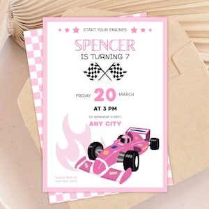 Puede incluir: Invitación de cumpleaños rosa con temática de coches de carreras. El texto dice "Start Your Engines" y "Spencer cumple 7". También incluye la fecha, la hora y el lugar. La invitación tiene un borde a cuadros rosa y un gráfico de coche de carreras rosa.