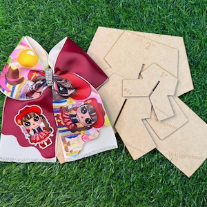 May include: A large hair bow with a rhinestone center, featuring a cartoon cowgirl design in red, white, and pink. Next to the bow are several brown acrylic templates, including a 2-inch and a 1-inch template.