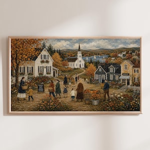 May include: A framed landscape painting depicting a small town scene with a white church, houses, and people walking on a path. The scene includes autumn trees, pumpkins, and a sign that reads MARKET TODAY APPLES PUMPKINS FLOWERS.