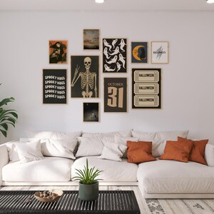 Puede incluir: Un sal&oacute;n decorado para Halloween con arte enmarcado. El arte incluye un esqueleto, fantasmas, una luna y el texto "October 31". Debajo del arte hay un sof&aacute; seccional blanco con cojines naranjas.