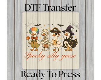May include: A Halloween-themed DTF transfer featuring four cartoon geese dressed in costumes. One goose is a clown, another a mummy, a pirate, and a witch. The text "Spooky silly goose" is below the geese, with "Ready To Press" at the bottom.