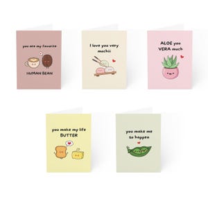 May include: Five greeting cards with pastel backgrounds and cute food illustrations. Text includes: you are my favorite HUMAN BEAN, I love you very mochiii, ALOE you VERA much, you make my life BUTTER, and you make me so happea.