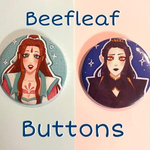 May include: Two round buttons with anime-style illustrations. One features a woman with red hair and a teal and pink outfit against a light blue background. The other button shows a person with black hair and a dark outfit on a blue background. Text reads "Beefleaf Buttons".