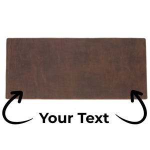 May include: A rectangular, brown leather desk mat with a textured surface. The mat has rounded corners and the text "Your Text" is displayed in white. Arrows point to the text.