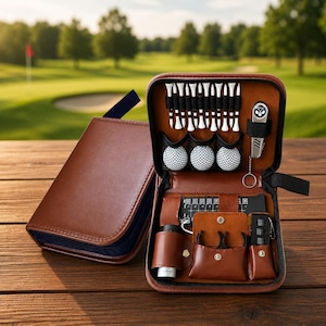May include: A brown leather golf accessory kit featuring a zippered case containing white golf tees, three dimpled golf balls, a metal divot tool, a black score counter, and small pouches for additional gear, all organized within a structured interior.
