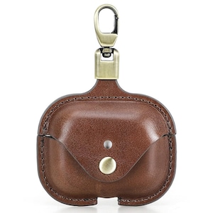 May include: Brown leather AirPod case with a brass-colored clasp and button closure. The case has a stitched border and a small flap. The top has a brass-colored clasp for attaching to a bag or keychain.