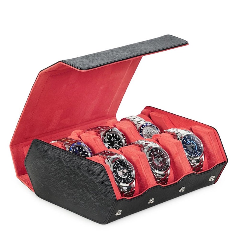 May include: A black watch case with a red interior, holding six silver and black wristwatches. The case is open, revealing the watches nestled in individual compartments. The watches have various face designs and band styles.