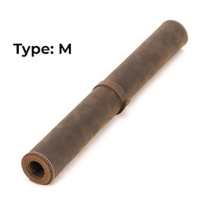 May include: Rolled brown leather mat with a strap closure. The mat is labeled "Type: M" in black text. The leather has a distressed appearance, and the edges are stitched with white thread.