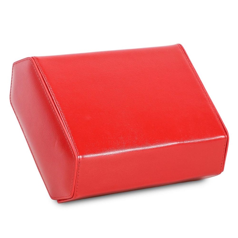 May include: A bright red, rectangular box with a slightly angled top. The box appears to be made of a smooth, possibly leather-like material, with visible stitching along the edges. The overall design is simple and modern.