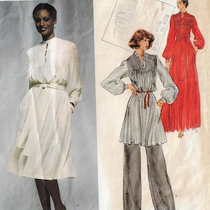 Può includere: Un cartamodello per un abito con due stili diversi. Il primo stile è un abito bianco con collo alto e maniche lunghe. Il secondo stile è un abito grigio con collo alto e maniche lunghe, abbinato a pantaloni larghi. Il cartamodello è di Simplicity e il numero è 9359.