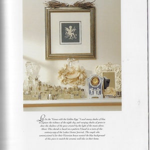 May include: A framed cross-stitch of a cherub with a bow and arrow, a white ceramic cherub sculpture, and a blue and white clock with cherubs on the face. The items are arranged on a shelf with a variety of silver and glass bottles.