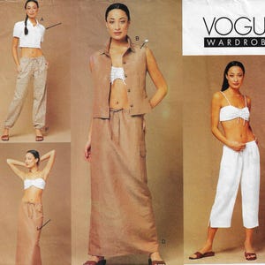 May include: A Vogue Wardrobe sewing pattern envelope featuring illustrations of clothing sets including a white collared crop top, tan patterned trousers, a tan sleeveless vest, a long tan skirt, a white strapless crop top, and white cropped trousers.