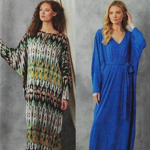 May include: Two long dresses. One is a patterned, multi-colored dress with a round neckline and long sleeves. The other is a solid blue dress with a V-neck, long sleeves, and a matching belt. Both dresses have a flowing, relaxed fit.