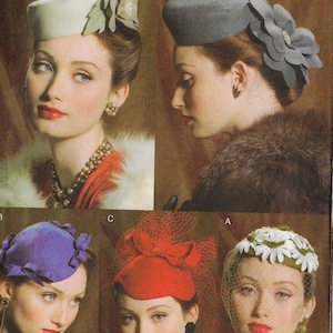 May include: A collection of vintage hats in various styles and colors. The hats include a white pillbox hat with a floral accent, a gray hat with a large flower, a purple hat with bow details, a red hat with a veil, and a white hat with daisy accents.