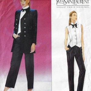 May include: A black and white illustration of a woman wearing a black suit with a white shirt and a black bow tie. The suit has a long jacket with a double-breasted closure and a high collar. The woman is wearing black pants and white shoes. The illustration is from a fashion pattern by Yves Saint Laurent, Vogue Paris Original.