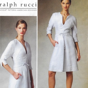 May include: A pale blue dress featuring a V-neck and tie waist. The dress has three-quarter length sleeves and pockets. The text "ralph rucci" and "VOGUE PATTERNS AMERICAN DESIGNER" are visible.