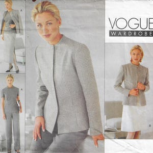 May include: A Vogue Wardrobe sewing pattern envelope featuring illustrations of a grey and white plaid jacket, a matching skirt, a sleeveless top, and trousers. The text VOGUE WARDROBE is printed in the upper right corner of the paper packaging.