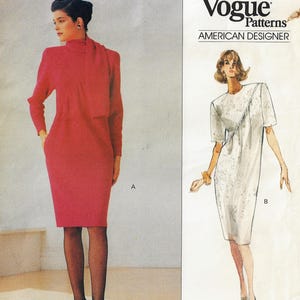 May include: Vogue Patterns American Designer sewing pattern for a dress with two styles. Style A is a red dress with a high neck and a long sleeve. Style B is a white dress with a round neck and a short sleeve. The pattern is for sizes 6-14.