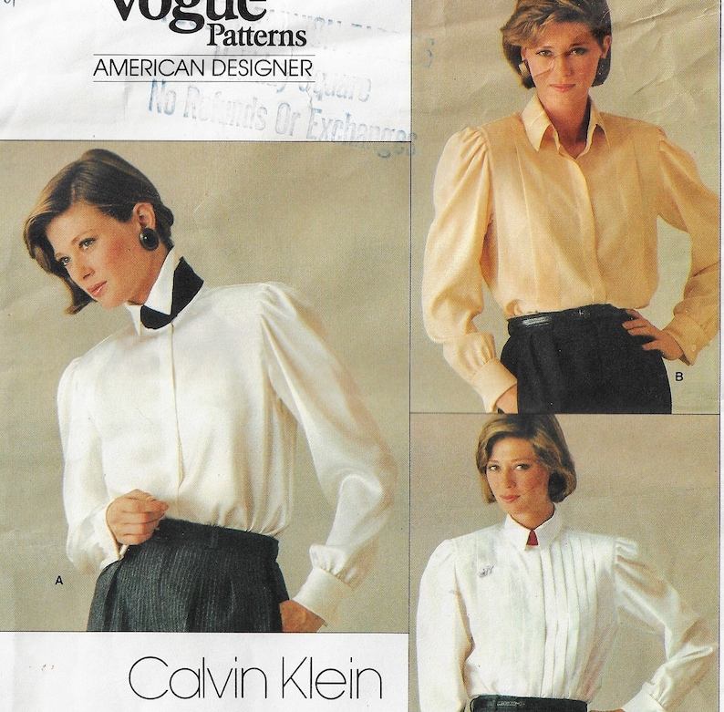 May include: A vintage sewing pattern for a white blouse with a high collar and puffed sleeves. The pattern is by Calvin Klein and is for Vogue Patterns, American Designer. The pattern includes three different views of the blouse.