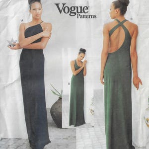 Puede incluir: Sobre de patrón de costura Vogue Patterns con dos vestidos largos hasta el suelo. El modelo A es un vestido negro de un solo hombro. El modelo B es un vestido verde oscuro sin mangas con cuello redondo y diseño de espalda cruzada al descubierto.