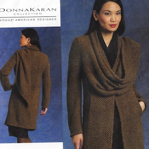 Pode incluir: Um casaco marrom comprido de manga comprida com gola de cachecol. O casaco é feito de um tecido texturizado e tem um padrão de chevron. A modelo está usando uma gola alta preta por baixo do casaco. O texto "DONNA KARAN COLLECTION VOGUE AMERICAN DESIGNER" é visível no topo da imagem.