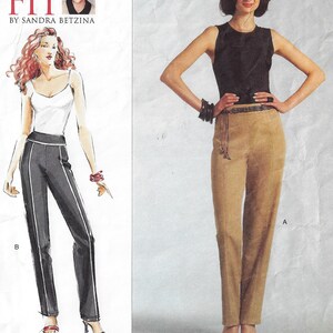 May include: A sewing pattern envelope titled FIT BY SANDRA BETZINA featuring a fashion illustration of a white tank top and dark trousers, alongside a photograph of a black sleeveless top paired with tan trousers and a thin waist belt.