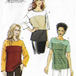 May include: A sewing pattern featuring three different blouse designs. One blouse is white, tan, and black. Another is yellow and burgundy. The third is green with a geometric pattern. The pattern includes a barcode and numbers.