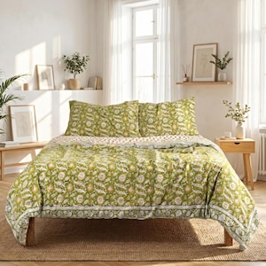 Può includere: Un letto con un copriletto verde a fantasia floreale e federe abbinate. La biancheria da letto presenta un motivo floreale bianco e giallo su sfondo verde. Il letto è su una struttura in legno e un tappeto tessuto.