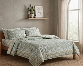 May include: A bed with a green floral patterned comforter and matching pillowcases. The bed is made up with a patterned sheet set. A framed botanical print and a potted plant sit on a shelf above the bed.