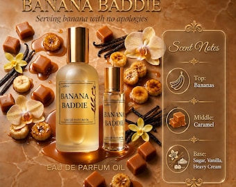 May include: Two glass bottles of LuvBev Fragrances Banana Baddie eau de parfum oil, featuring gold caps and labels. The display includes scattered caramel cubes, sliced bananas, vanilla bean pods, and orchid flowers with a scent notes chart.