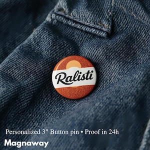 Puede incluir: Un botón redondo con la palabra "Ralisti" en escritura blanca sobre una banda blanca. El fondo es naranja y marrón con un diseño de sol. El botón mide aproximadamente 7,6 cm de diámetro y está sobre una chaqueta vaquera.